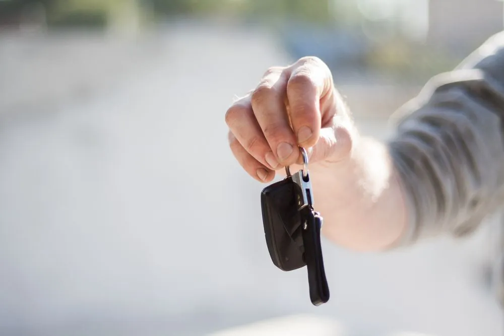 Hand holding car keys, a reminder that auto insurance is required before you drive