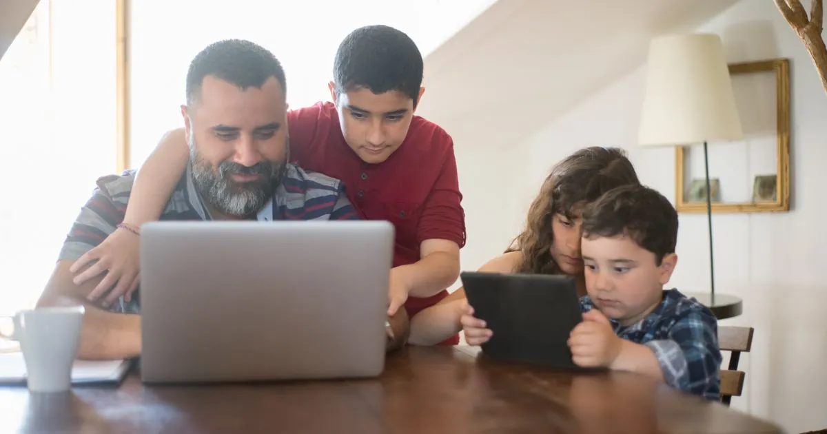 Family comparing insurance in Canada on a laptop at the kitchen table