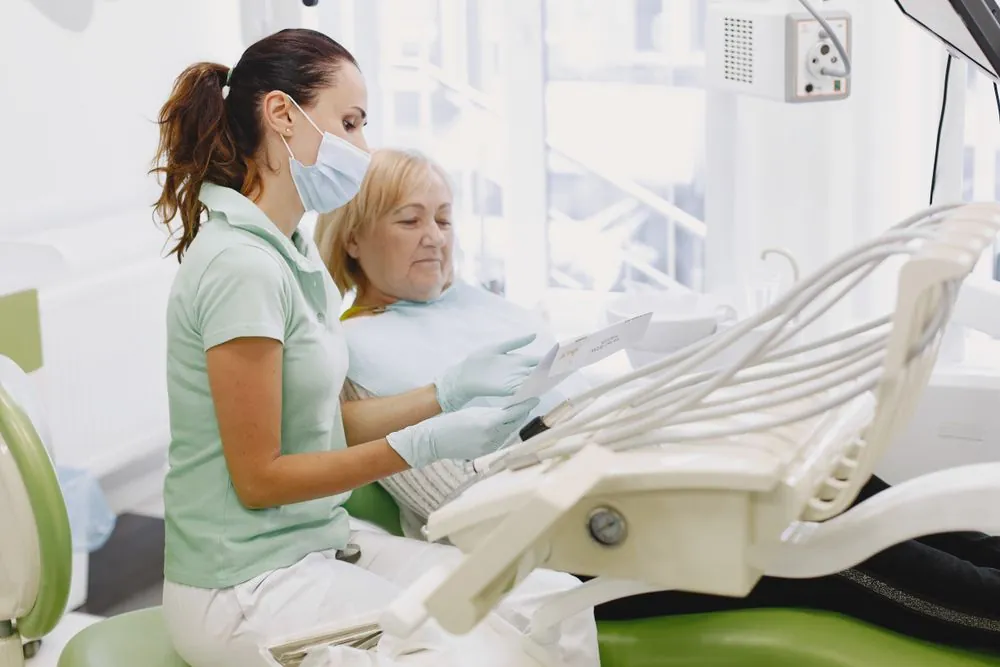 Dentist reviewing a treatment plan with an older patient, a cost dental insurance can help cover