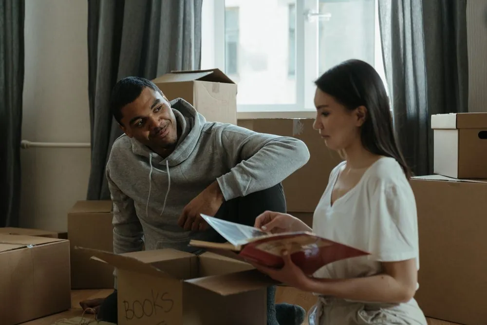 Couple unpacking boxes in a new apartment, where tenant or condo insurance covers their belongings